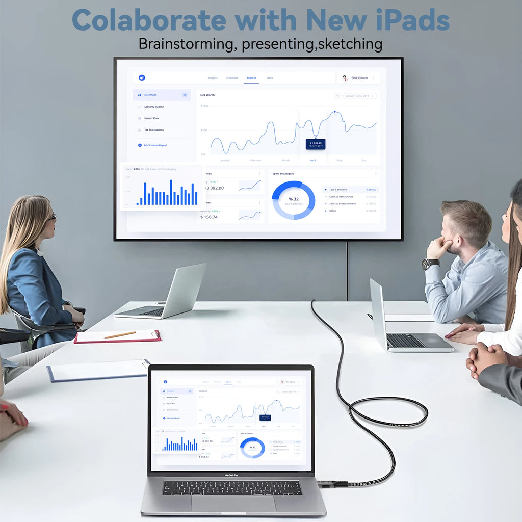 People working in a meeting room with laptops and a large screen displaying graphs.